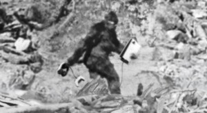a photo illustration of a sasquatch walking into a forest carrying a playstation 5