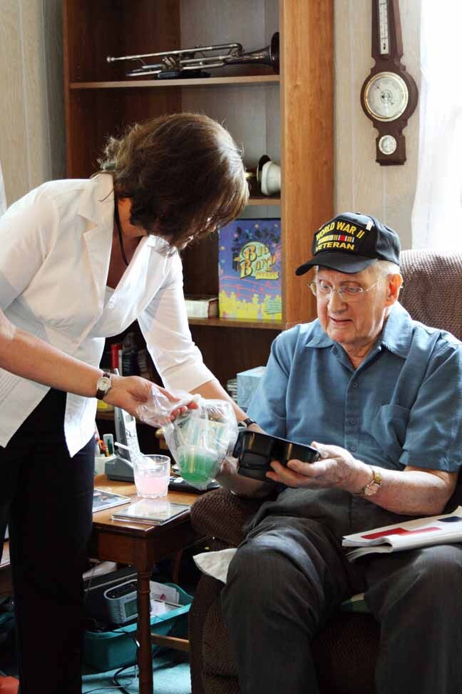 A Meals On Wheels volunteer serves a member of the greatest generation