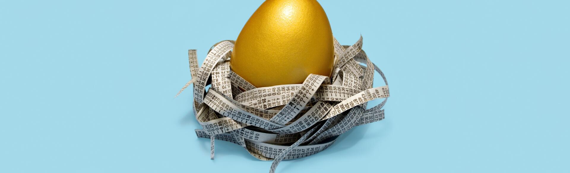 Golden egg in nest of strips of newspaper stock prices