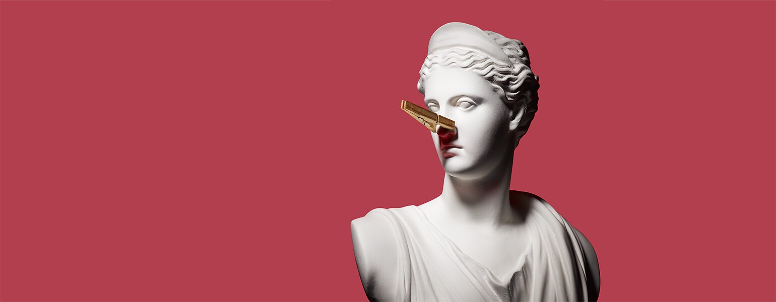 A white bust statue wears a clothespin on its nose to combat the smell of perimenopause symptoms.
