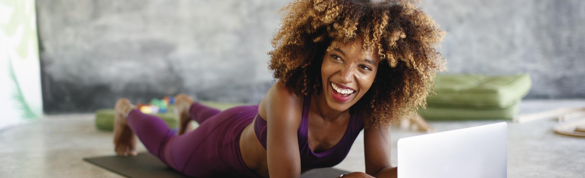 Woman on her laptop at home taking online fitness classes