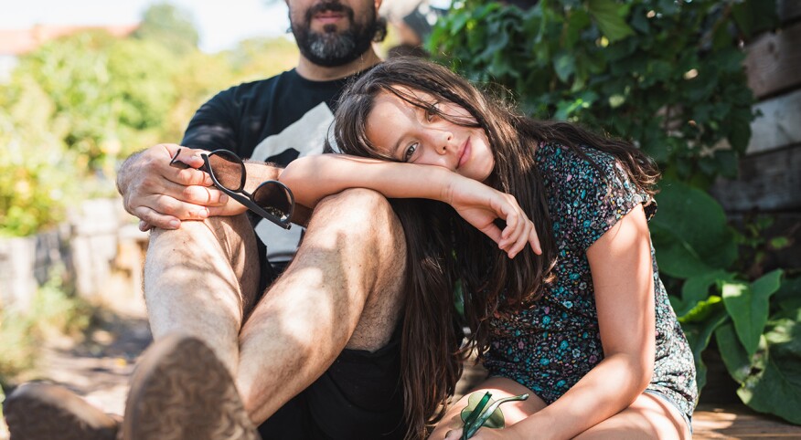 Daughter leaning on her dad's lap.