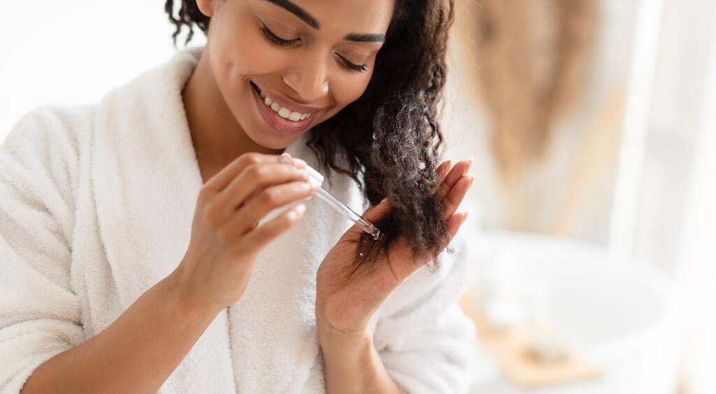 image_of_woman_applying_oil_to_ends_of_hair_GettyImages-1322880152_1800