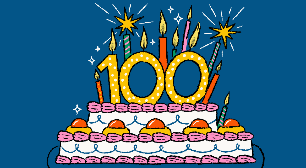 Women raising glasses over a cake with an 100 candle