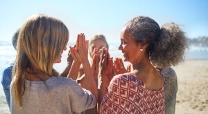 Picture of women smiling and standing in a circle