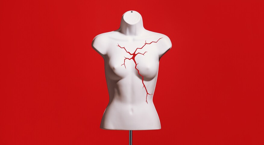 Mannequin bust cracked above heart against a red background
