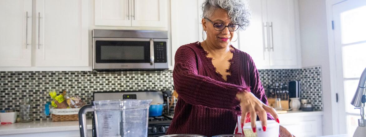 Woman in kitchen making a smoothie