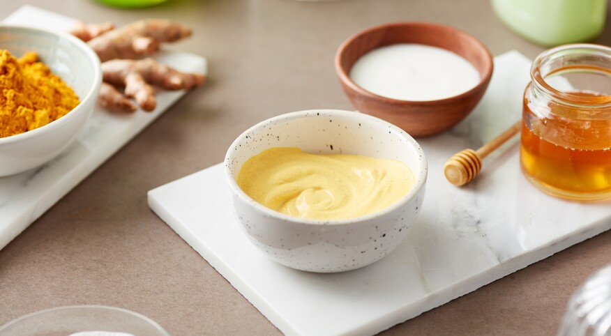 Still Life Of Homemade Organic Turmeric Mask On Marble Board with yogurt and honey.