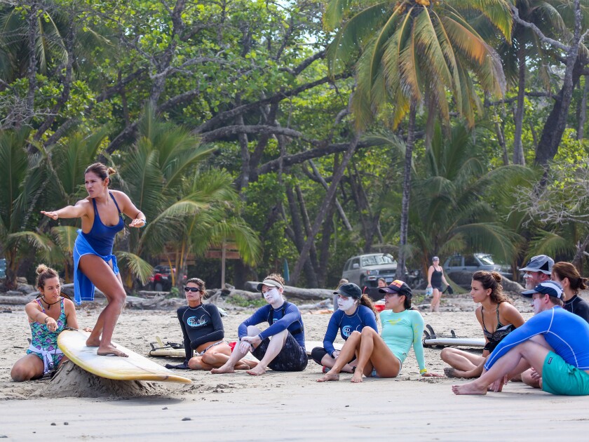 A group learns to surf with Pura Vida Adventures.