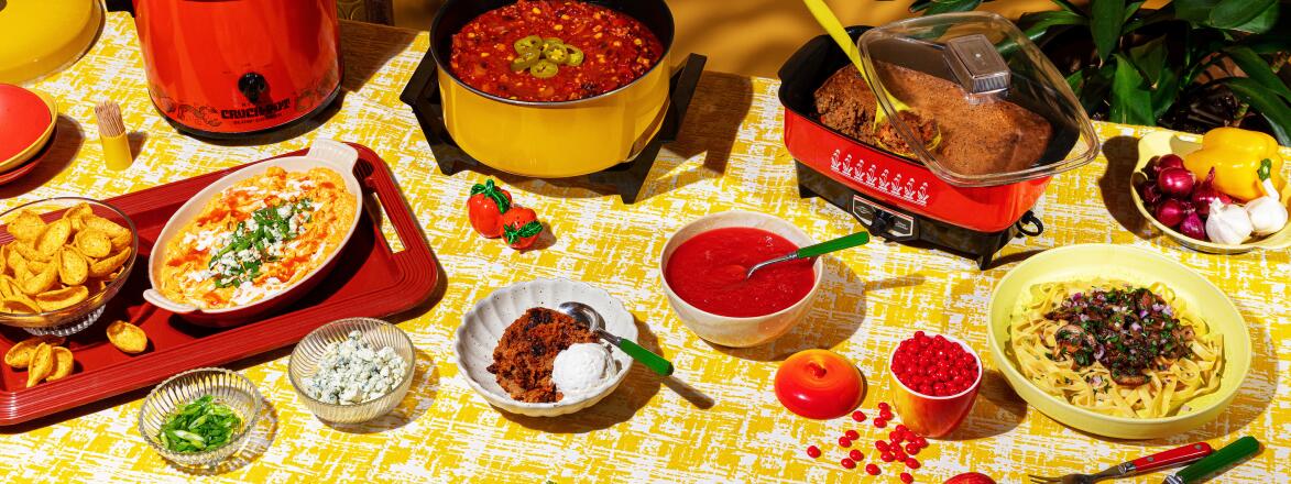 Overhead shot of crockpot meals and garnishes on yellow tablecloth