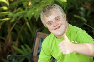 Cute handicapped boy showing thumbs up outdoors