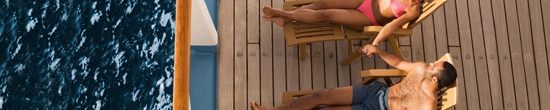 Couple laying on chairs on cruise deck