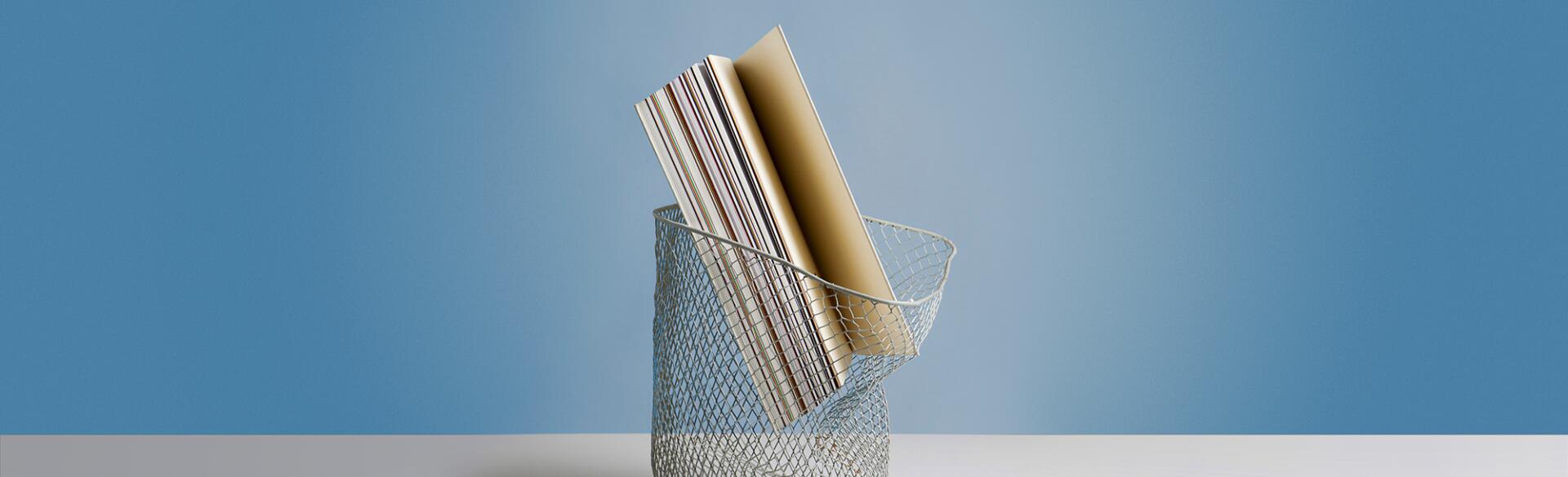 Large book in wastepaper basket