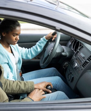 Father teaching daughter how to drive stick shift