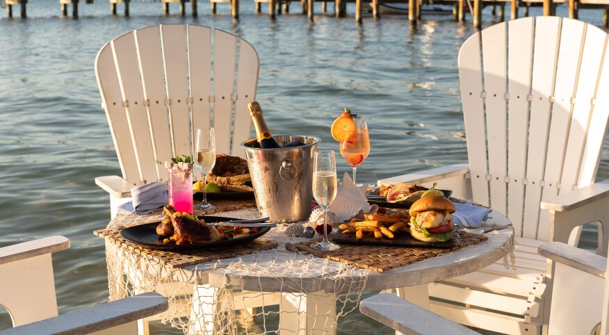 Food sitting outside on a table with chairs