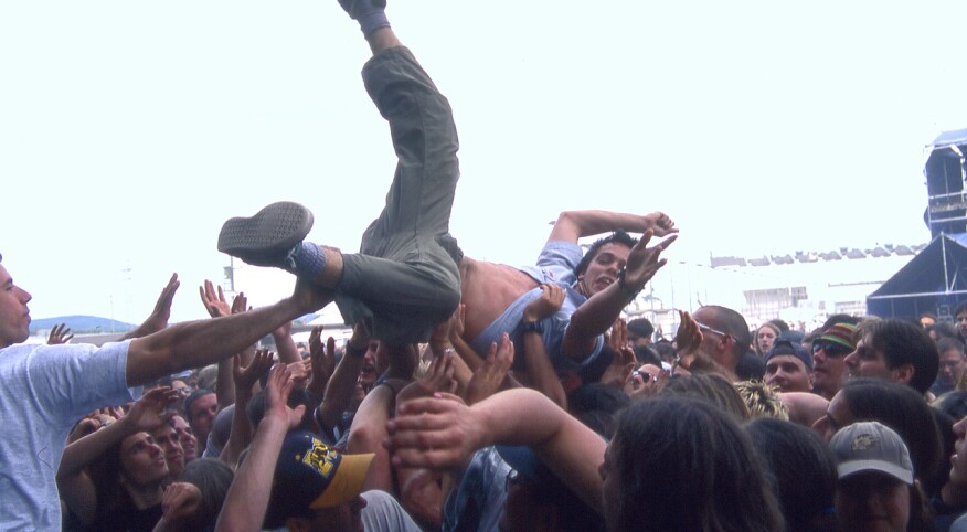 Teenager being lifted in mosh pit