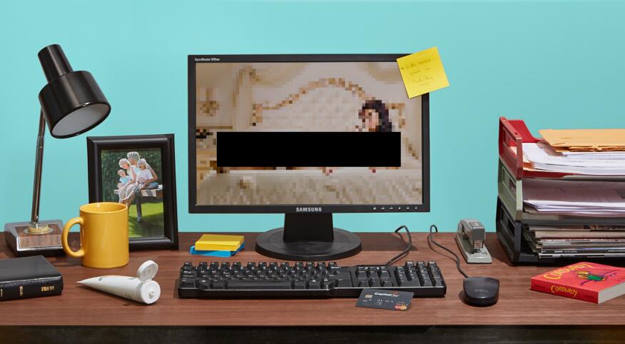 A photo of a seemingly normal work desk, but the computer has a lewd chatroom website on.