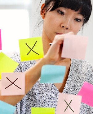 Woman crossing off colorful post-its