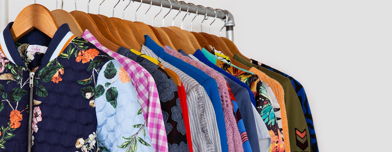 image of clothes on rack by armoire