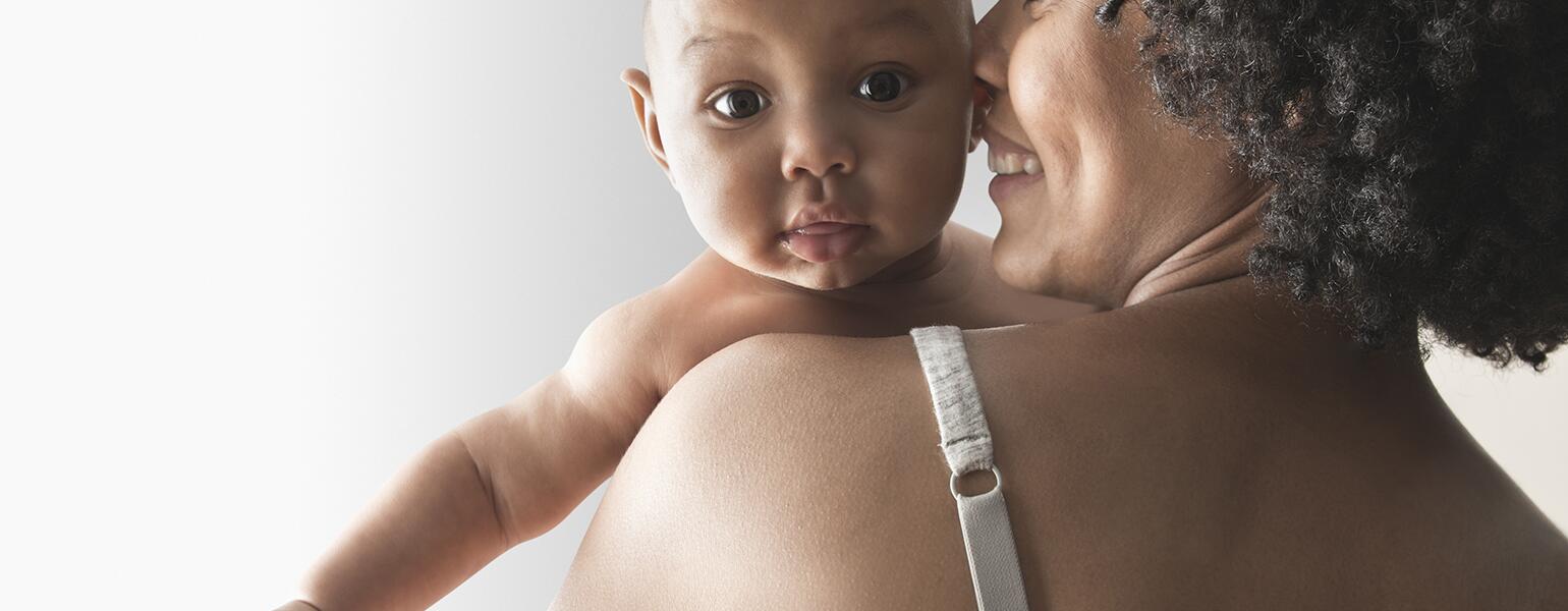 A woman holds her baby after a breast feeding session.