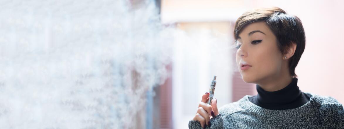 close up of a young woman smoking a vape pen