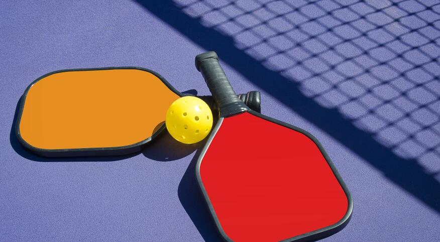 Pickleball - Two Paddles and A Ball in Net Shadow