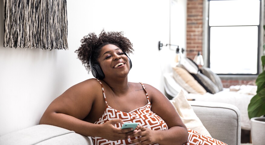 image_of_Woman_listening_to_music_on_phone_GettyImages-1198641540_1800