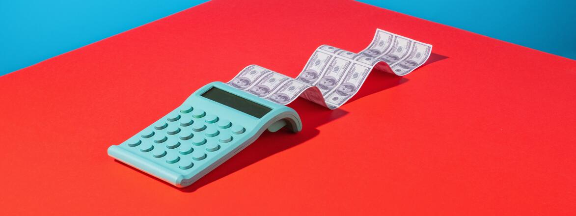 Calculator printing dollar bills on bright background
