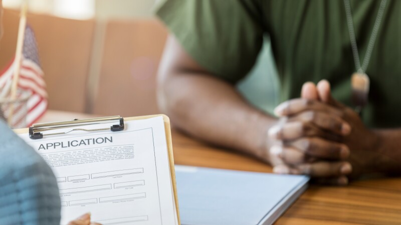 Close up of bank loan application and soldier's clasped hands