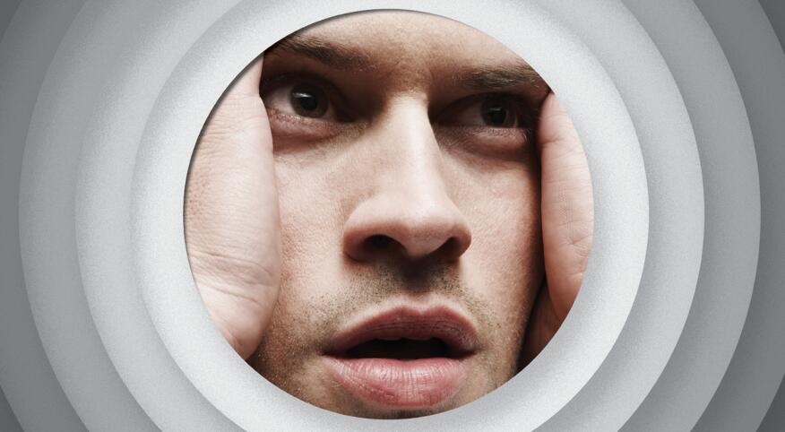 Close up of a man holding his face with very stressed expression