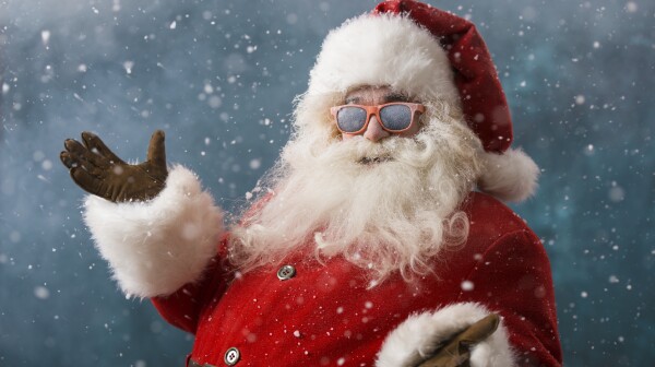Santa Claus wearing sunglasses dancing outdoors at North Pole