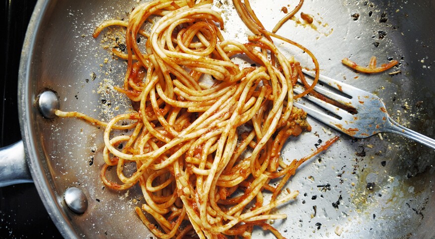 Partially eaten pasta in a pan with a fork