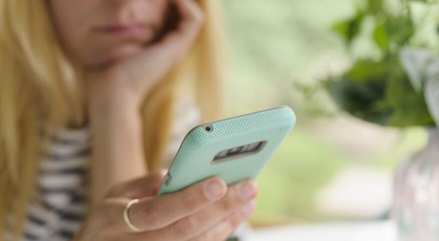 upset woman looking at her phone