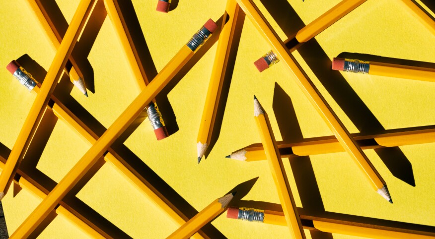 Layers Of Pencils Scattered On yellow Paper