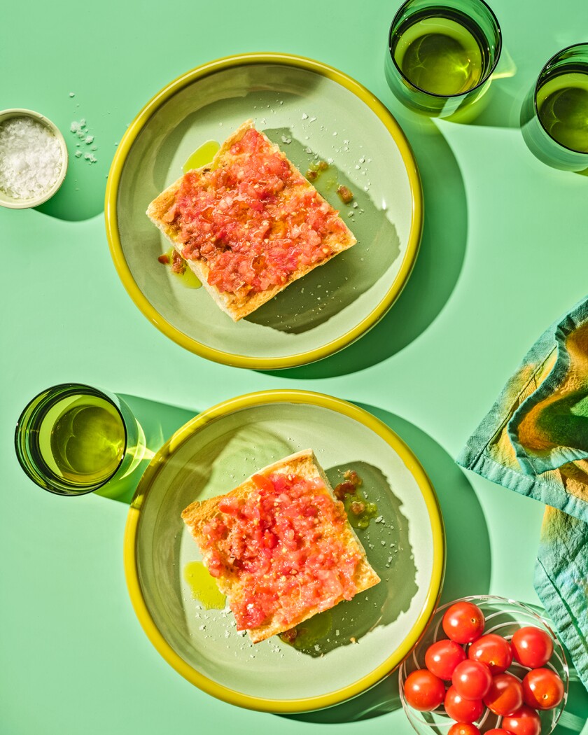 Two slices of Tomato Toast from overhead on a green background