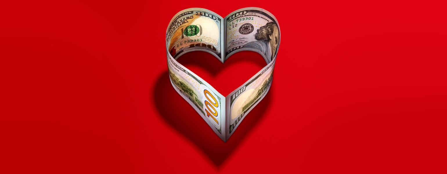 heart made of 100 dollar bills on a red background