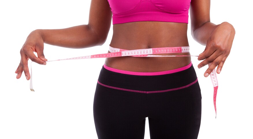 African American athlete with tape measure around stomach