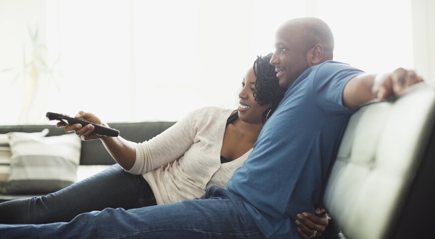 couple sitting on couch watching tv