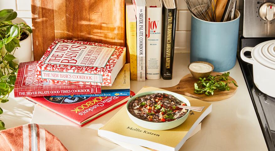 A collection of old cookbooks in a kitchen scene
