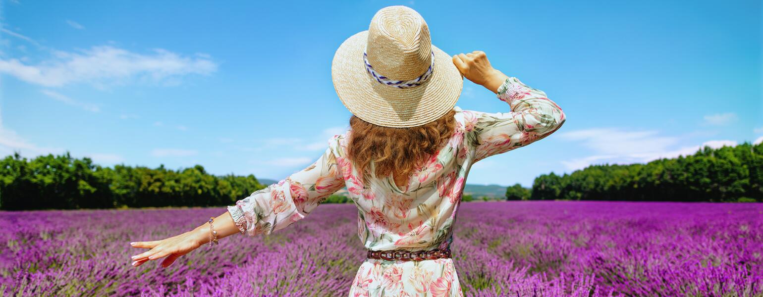 woman in sundress walking through flower field