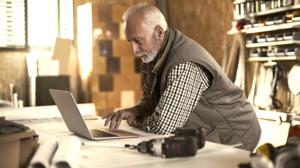 Mature designer looking at laptop