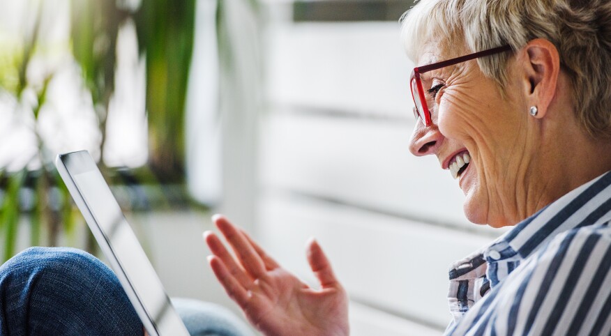 Smiling beautiful senior woman using digital tablet at home