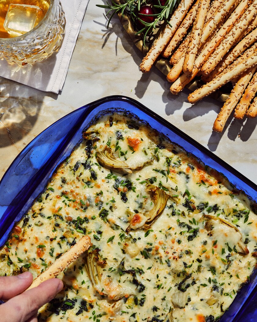 Spinach Dip and breadsticks on a decorated table set for the winter holidays