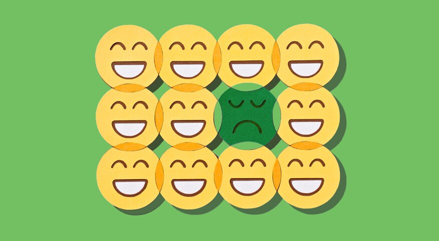 Rows of smiling faces with one sad face in the middle on a green background