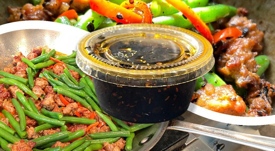 Container of takeout sauce and prepared meal of green beans and meat