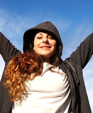 Young woman with arms up in the park