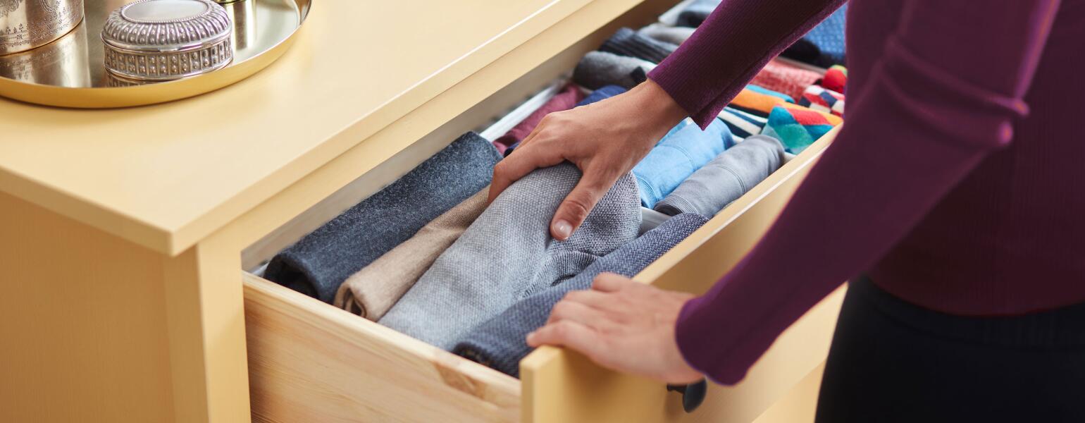 Woman organizing clothes in a dresser drawer