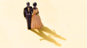 wedding cake topper of couple with shadow showing couple separate 