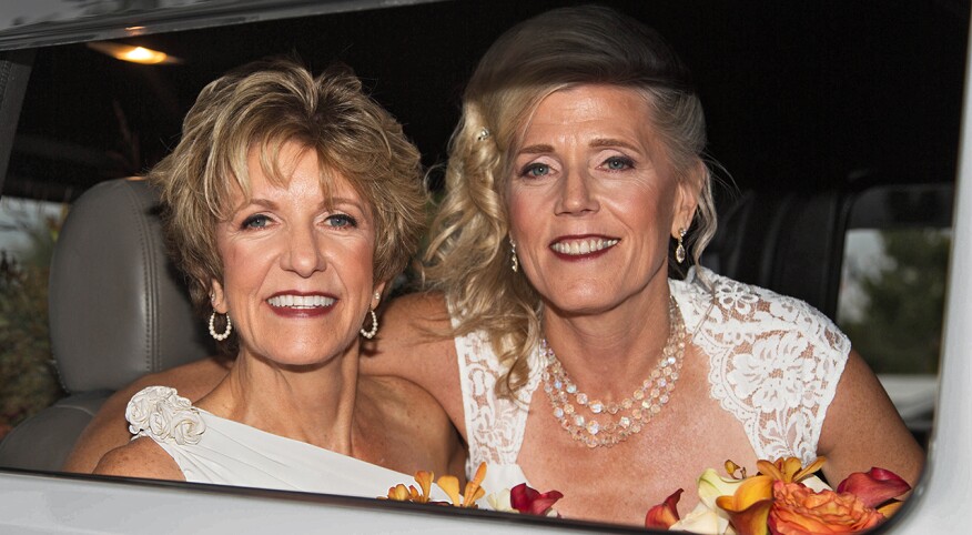 Two women smiling in car, just married