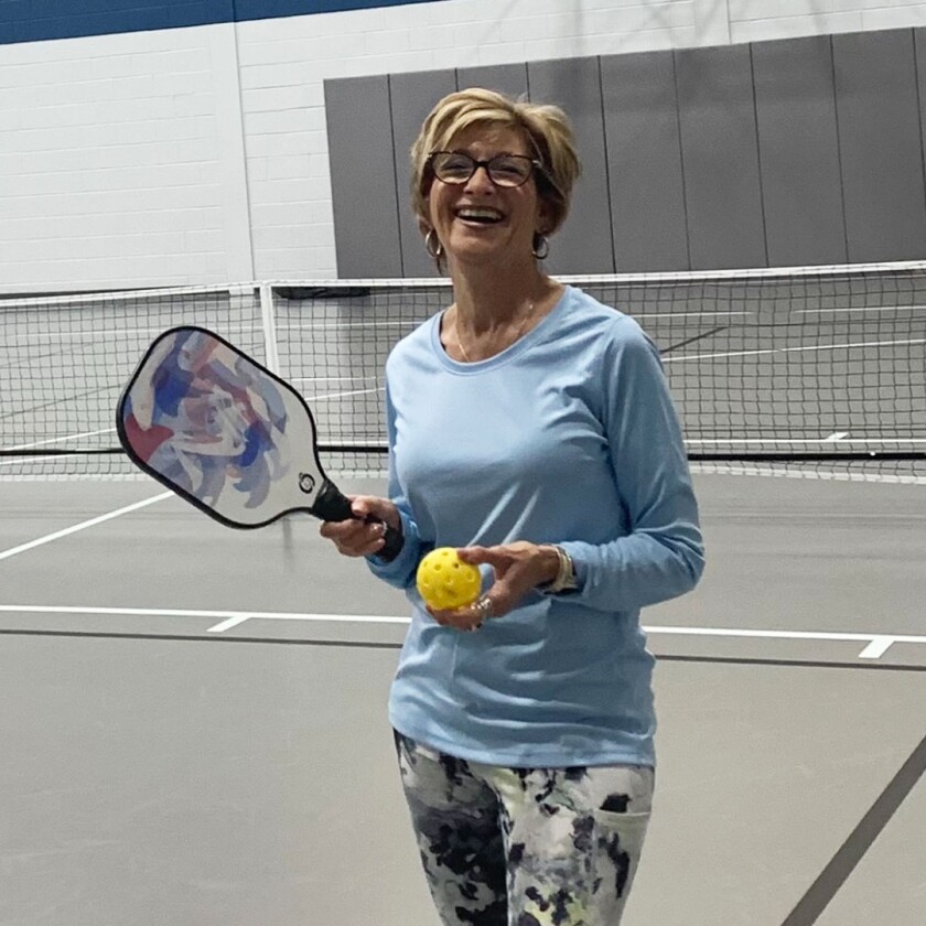 Woman holding pickle ball racket 